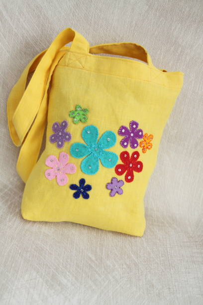 女の子のための黄色のリネントートバッグ。子供の夏のバッグに装飾品。プラスチックなしで、天然素材からのハンドバッグ。排他的な設計。子供のための手作りのトートバッグ。 - appliqué ストックフォトと画像