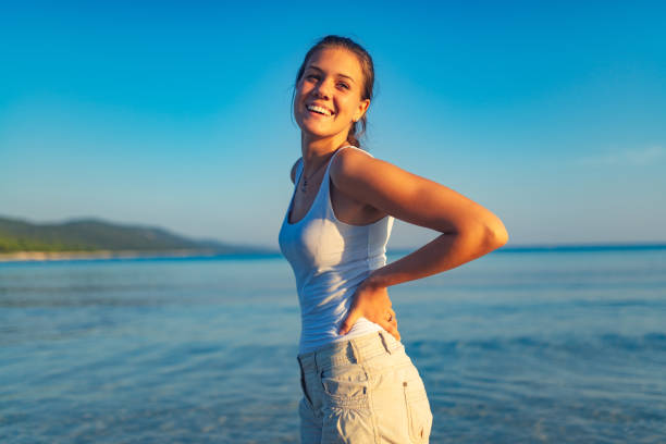 Beautiful bond woman dancing and having fun on beach, enjoying the summer.