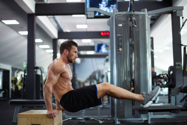String athlete with a beard preparing to do a tricep dip exercise in the gym String athlete with a beard preparing to do a tricep dip exercise in the gym. chest dip on athletic workout stock pictures, royalty-free photos & images