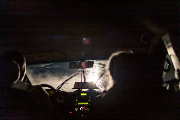 por la noche, en la habana, un taxista en el trabajo con un pasajero masculino sentado junto a él en el asiento delantero. - c02 fotografías e imágenes de stock