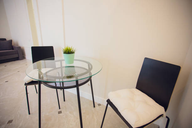 istock Glass table and white modern chairs in dining room. 1146136388