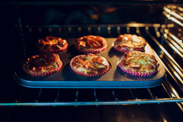 istock Woman baking cupcakes in the oven hand. 1146136638