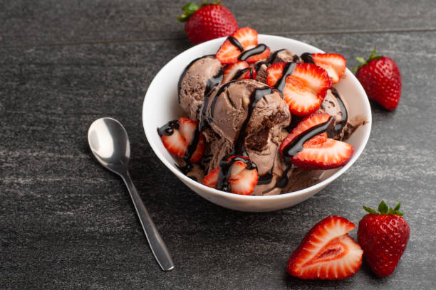 istock chocolate ice cream with strawberries on a dark background with a spoon, summer mood 1146136819
