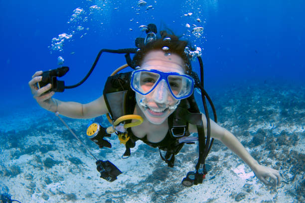 mujer buceadora sonriendo bajo el agua - buceo con equipo fotografías e imágenes de stock