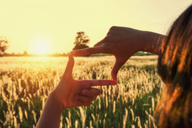 istock people make hand framing looking distant view sunrise. business concept 1146139653