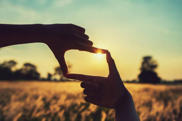 istock people make hand framing looking distant view sunrise. business concept 1146139654