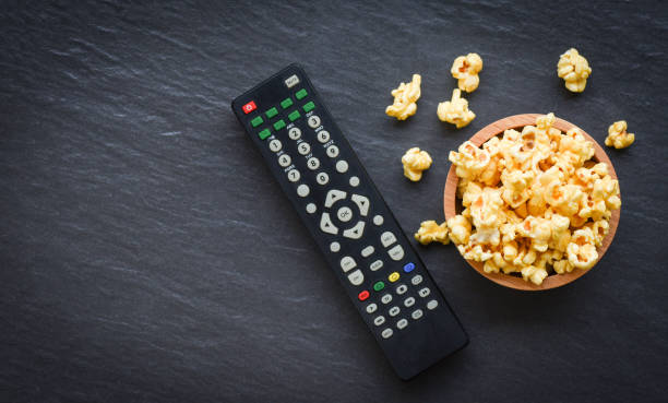 istock Cinema concept popcorn and remote control on wooden table backgroubd top view 1146141450