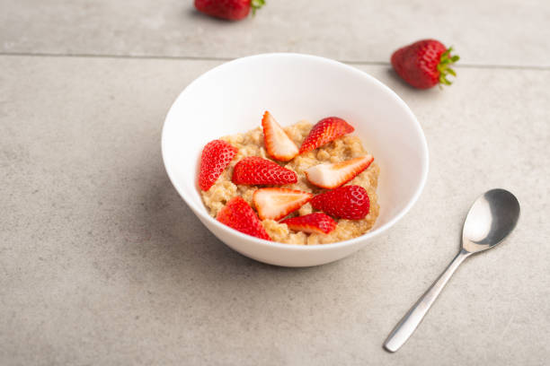 istock breakfast of oatmeal with strawberries, flat lay 1146142074