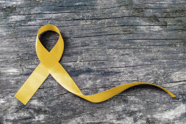 Yellow ribbon symbolic color for Sarcoma Bone cancer awareness and suicide prevention on aged wood (isolated with clipping path) Yellow ribbon symbolic color for Sarcoma Bone cancer awareness and suicide prevention on aged wood (isolated with clipping path) suicide photos stock pictures, royalty-free photos & images