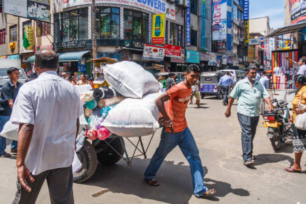 Busy street in the Pettah Colombo, Sri Lanka - March 16th 2011: Man pulling laden cart through a busy street in the Pettah district. This is the trading and market area of the city. taxi sri lanka stock pictures, royalty-free photos & images