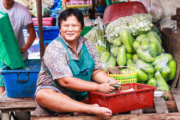 lächelnde verkäufer auf khlong toei markt. - khlong toei stock-fotos und bilder