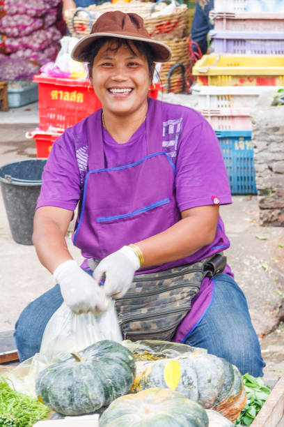 lächelnde verkäufer auf khlong toei markt. - khlong toei stock-fotos und bilder
