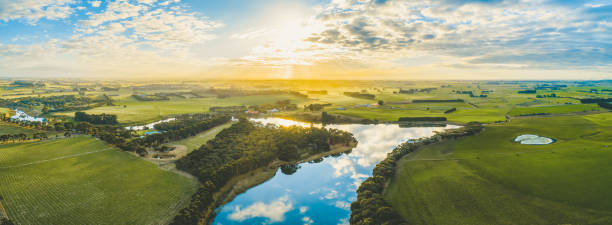 istock Sun setting over scenic Australian countryside grasslands and pastures with river passing through - aerial panorama 1146154917