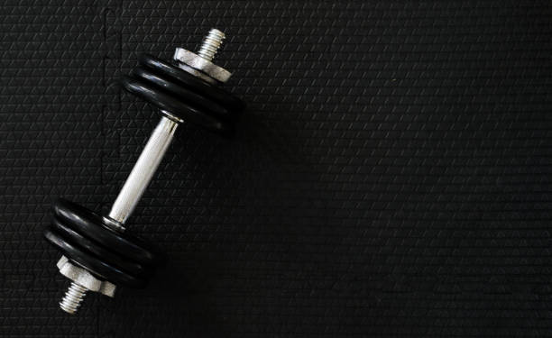 istock Top view of Iron dumbbells or weights on black floor with copy space for text. Flat lay composition. Health care concept. 1146156473