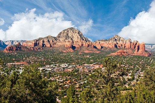 The American Southwest has some amazing landscapes, especially the rock formations. In the late evening, as the sun sets, the red rocks take on an even more colorful glow. This view of Capitol Butte and the town was taken from Airport Mesa in Sedona, Arizona, USA.