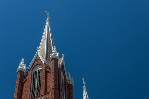 Gothic revival church steeples with crosses, very sunny day, blue sky, horizontal aspect