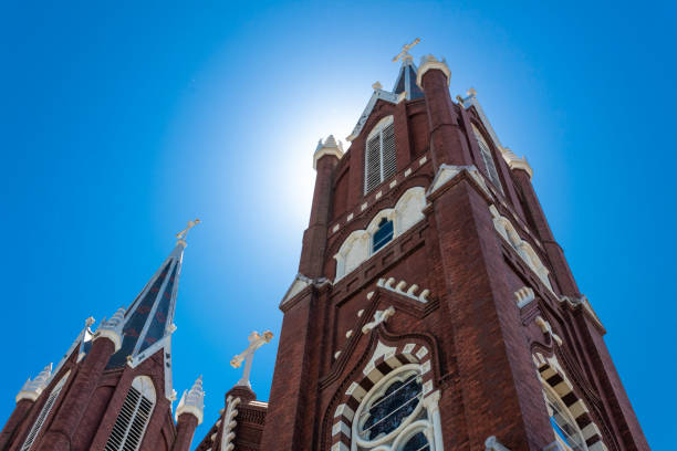 istock Sunlight glow from behind a beautiful Gothic Revival church, three crosses, blue sky 1146167438