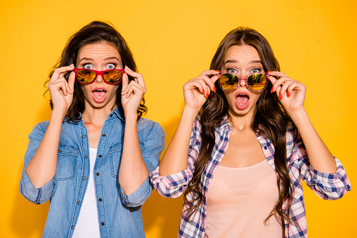 Close up photo charming funny hipsters person astonished impressed incredible information bargain news summer travel touch modern specs open mouth checked shirts denim isolated yellow background.
