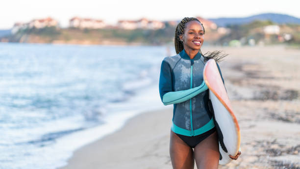 istock Surfer girl walking with surfboard on the beach 1146176080