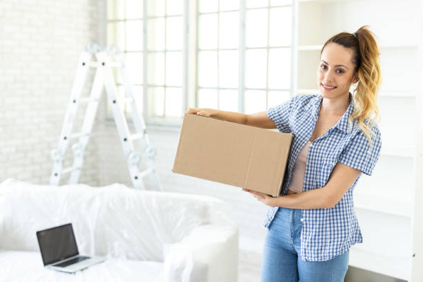 istock Woman unpacking boxes in new home 1146176167