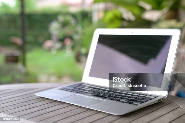 Laptop On Wooden Table Stock Photo - Download Image Now - Laptop, Yard - Grounds, Cable