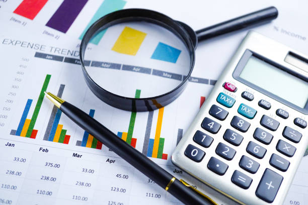 istock Magnifying glass on charts graphs spreadsheet paper. Financial development, Banking Account, Statistics, Investment Analytic research data economy, Stock exchange trading, Business office company meeting concept. 1146192561