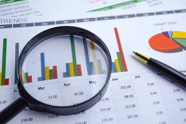 istock Magnifying glass on charts graphs spreadsheet paper. Financial development, Banking Account, Statistics, Investment Analytic research data economy, Stock exchange trading, Business office company meeting concept. 1146193987
