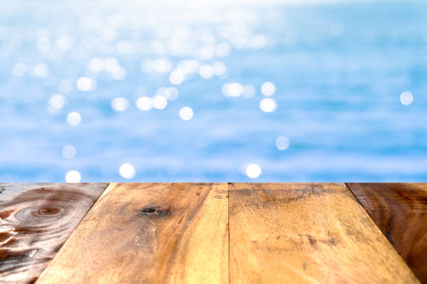 istock Selective focus of old wood table with blur beautiful beach background for display your product. 1146198520
