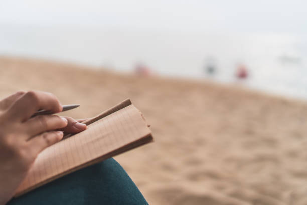 istock Woman hand writing down in small white memo notebook for take a note not to forget or to do list plan for future. 1146198540