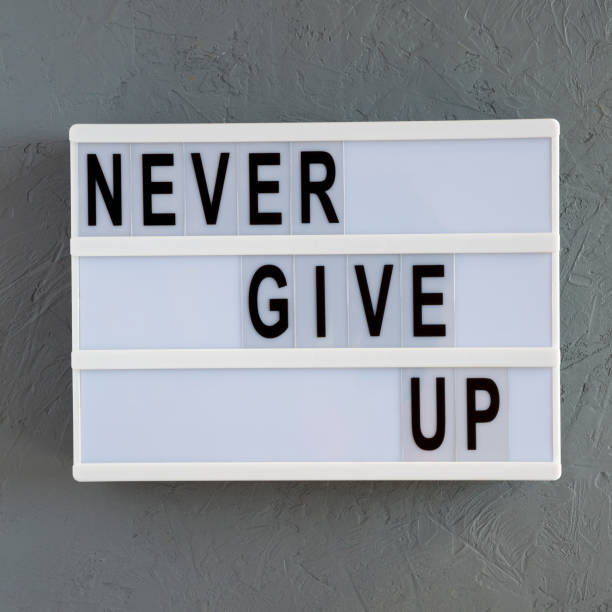 istock 'Never give up' words on a modern board over concrete background. Flat lay, from above, overhead. Close-up. 1146199307