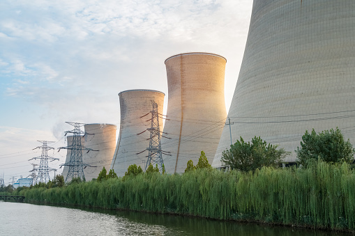power plant at dusk, sunset light shines on the cooling towers