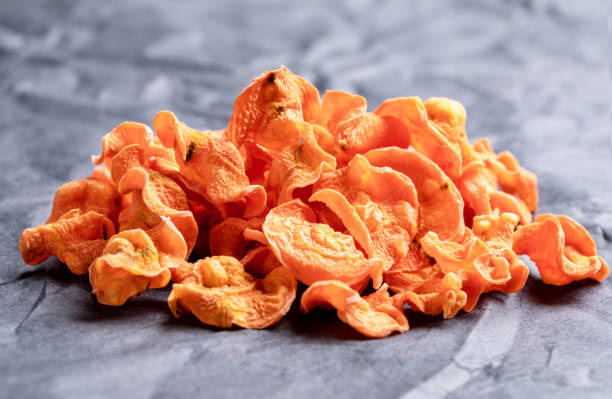 front view to small bunch of orange carrot chips on rumpled black paper. - root paper black textured imagens e fotografias de stock