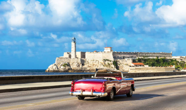 아메리칸 레드 1954에서 컨버터블 빈티지 자동차 프롬 나드 말 레 콘 및 배경에서 카 스틸로 드 로스 트레스 예 스 델 모로 인 하바나 시티 쿠바-세리에 쿠바 리 포티지 - cuba usa vintage car car 뉴스 사진 이미지