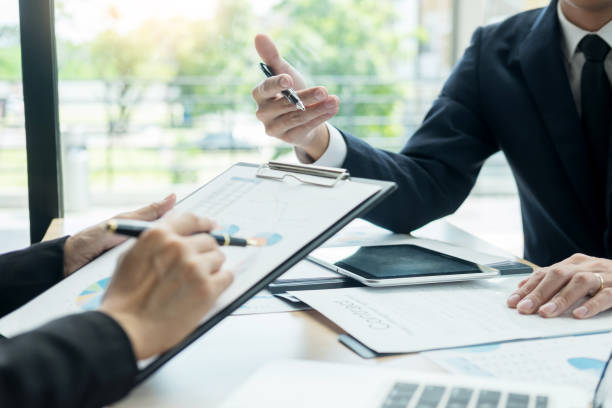 istock Businessmen Discussing Over Document At Desk In Office 1146210532