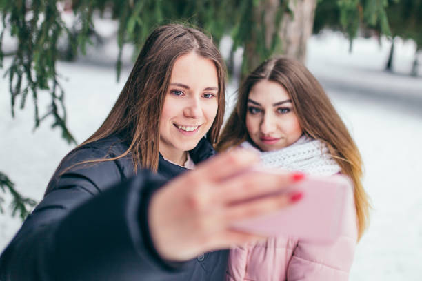 istock Two young cheerful girlfriends taking selfie in the winter outside 1146213304