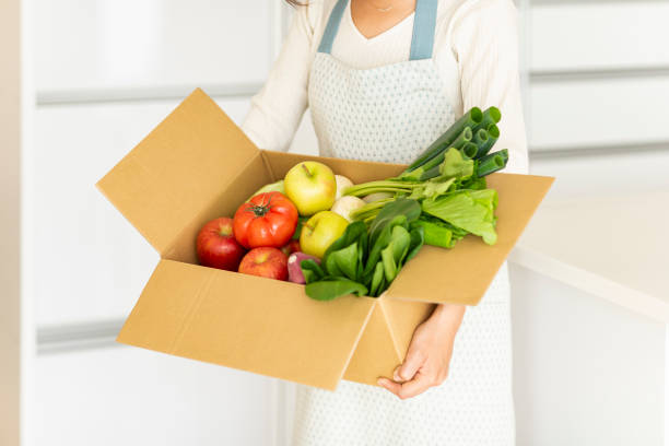 istock Housewife with cardboard box containing various vegetables 1146213323