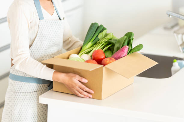 istock Housewife with cardboard box containing various vegetables 1146213326