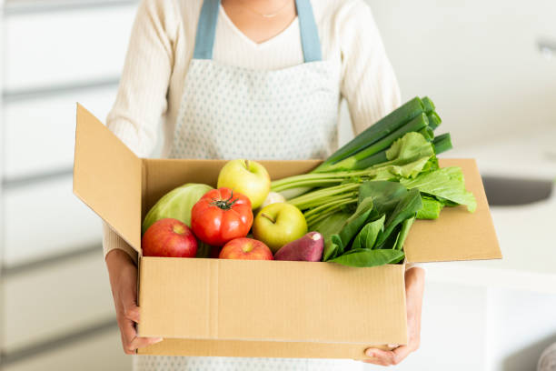 istock Housewife with cardboard box containing various vegetables 1146213327