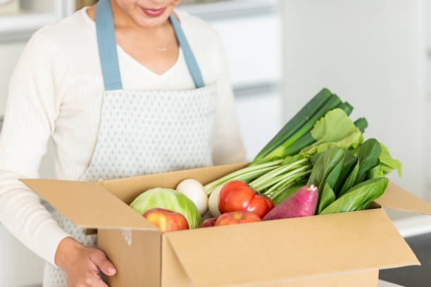 istock Housewife with cardboard box containing various vegetables 1146213328