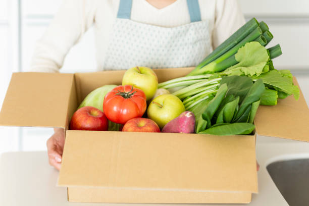 istock Housewife with cardboard box containing various vegetables 1146213368