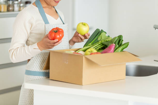 istock A cardboard box containing various vegetables and a housewife 1146213369