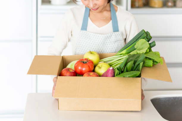 istock Housewife with cardboard box containing various vegetables 1146213379