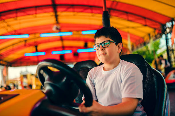 istock Boy driving bumper car in amusement park 1146214564
