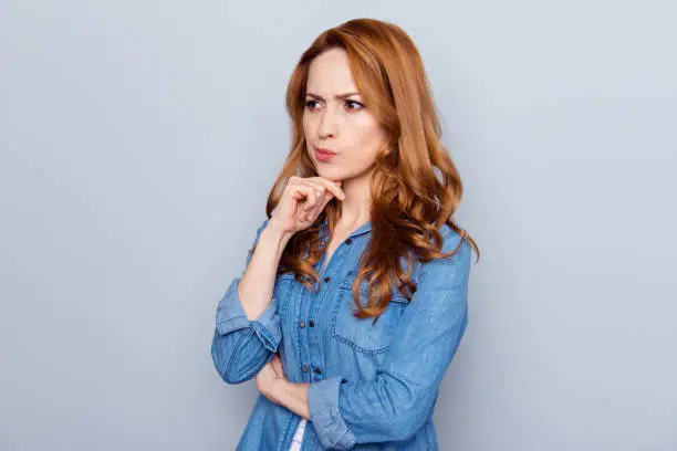 Photo of Close up photo beautiful amazing she her lady not smiling look side empty space hmm arm finger chin not sure right way learn study teach wear casual blue jeans denim shirt isolated grey background