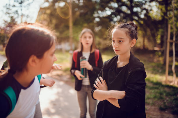 Girl bullying girl at schoolyard Girl wearing black hoodie bullying girl at schoolyard incidental people stock pictures, royalty-free photos & images