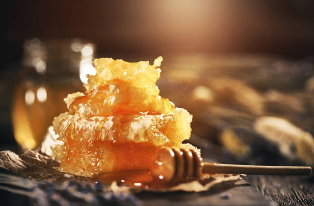 istock Honeycomb and bamboo dipper on wooden table 1146218171