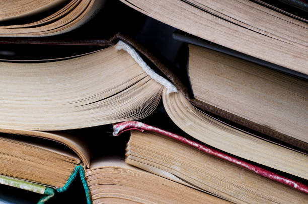 istock Stack of books piled against blue background. School concept. 1146222534