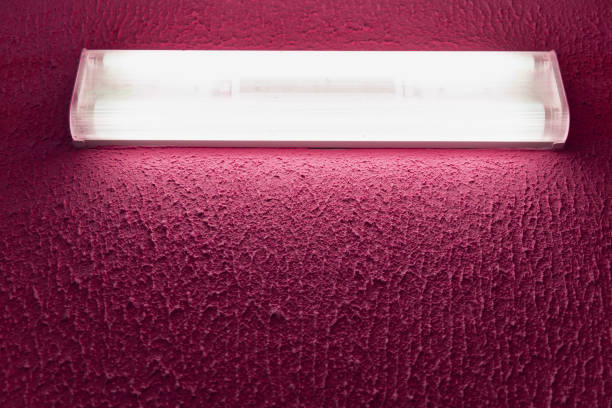 light fluorescent lamp with white light on the wall with pink surface