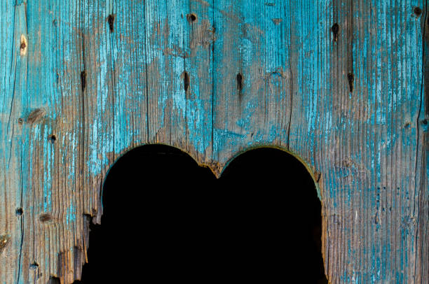 Heart as a cutout in the wooden door of a toilet house