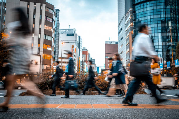仕事からの途中でぼやけたビジネスの人々 - オフィス街　日本 ストックフォトと画像